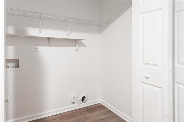 washroom with dark wood-style flooring, hookup for a washing machine, hookup for a gas dryer, laundry area, and baseboards