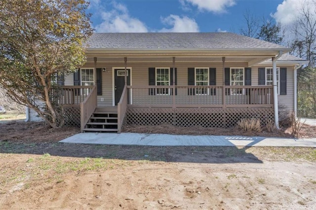 view of front of property featuring covered porch and a shingled roof