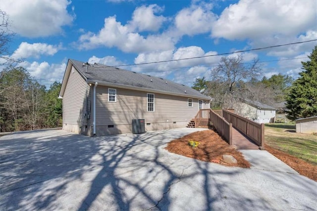 view of side of home with central AC and crawl space