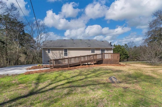 rear view of property with a lawn and a wooden deck