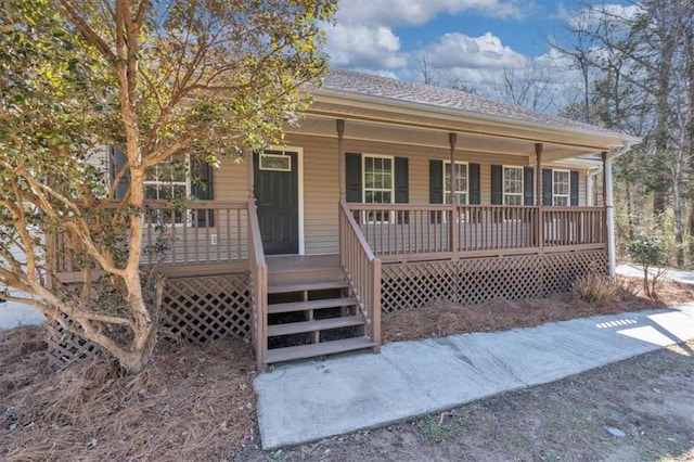 view of front of house with covered porch and a shingled roof