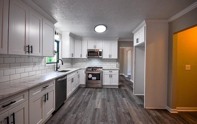 kitchen with sink, white cabinets, stainless steel appliances, dark hardwood / wood-style flooring, and ornamental molding