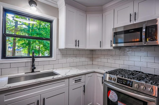 kitchen with white cabinets, stainless steel appliances, tasteful backsplash, and a wealth of natural light