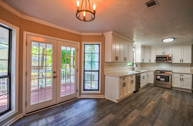 kitchen with hanging light fixtures, white cabinetry, dark wood-type flooring, and stainless steel appliances