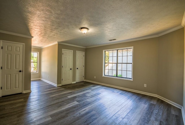 spare room with a textured ceiling, dark hardwood / wood-style floors, and ornamental molding