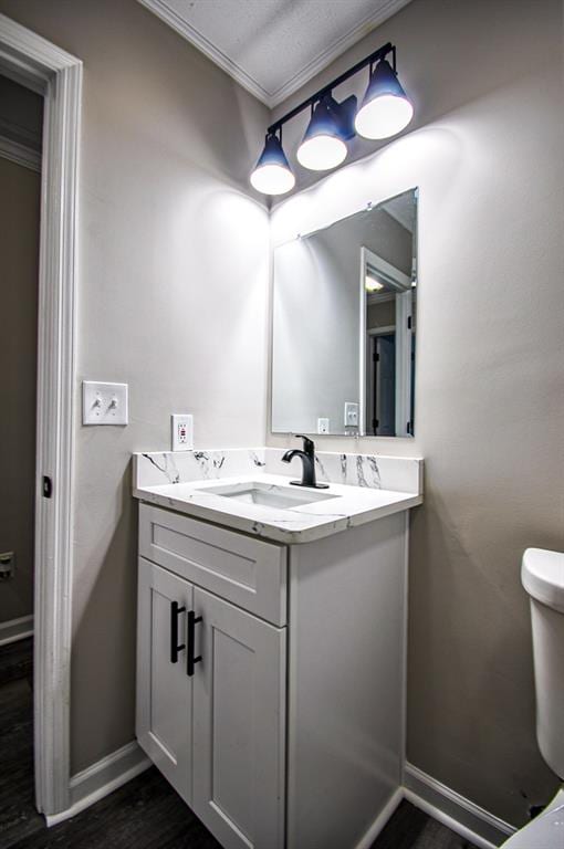 bathroom with hardwood / wood-style floors, vanity, and toilet