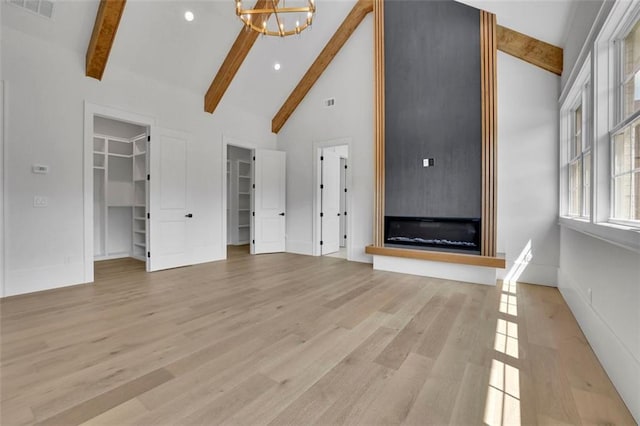 3893 Indian Shoals Rd, Dacula, GA 30019 - unfurnished living room with high vaulted ceiling, beamed ceiling, a chandelier, light wood-type flooring, and recessed lighting