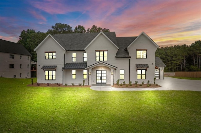 3893 Indian Shoals Rd, Dacula, GA 30019 - back of house at dusk featuring french doors, a standing seam roof, a lawn, driveway, and a metal roof