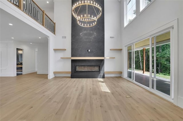 3893 Indian Shoals Rd, Dacula, GA 30019 - unfurnished living room featuring a high ceiling, wood finished floors, a fireplace, a chandelier, and recessed lighting