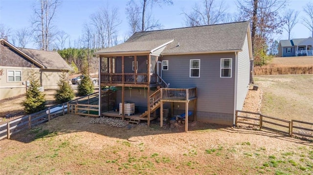 rear view of property with a sunroom, a fenced backyard, stairs, and a deck