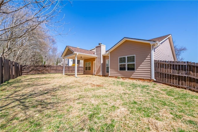 back of house featuring a yard and a fenced backyard