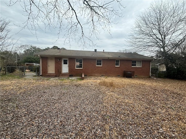 back of house featuring entry steps, central AC, brick siding, fence, and crawl space