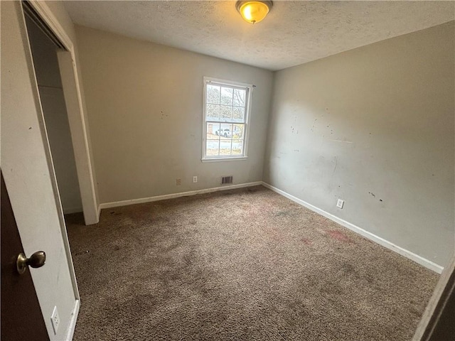 unfurnished bedroom with a closet, carpet flooring, a textured ceiling, and baseboards