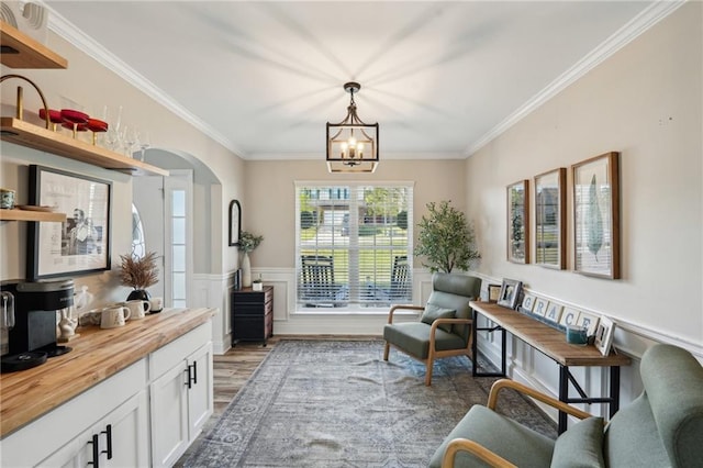 45 Peregrine Ln S, Dawsonville, GA 30534 - living area with a wainscoted wall, wood finished floors, ornamental molding, arched walkways, and a notable chandelier