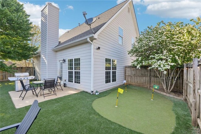 45 Peregrine Ln S, Dawsonville, GA 30534 - rear view of house featuring a chimney, a fenced backyard, a yard, a patio, and roof with shingles
