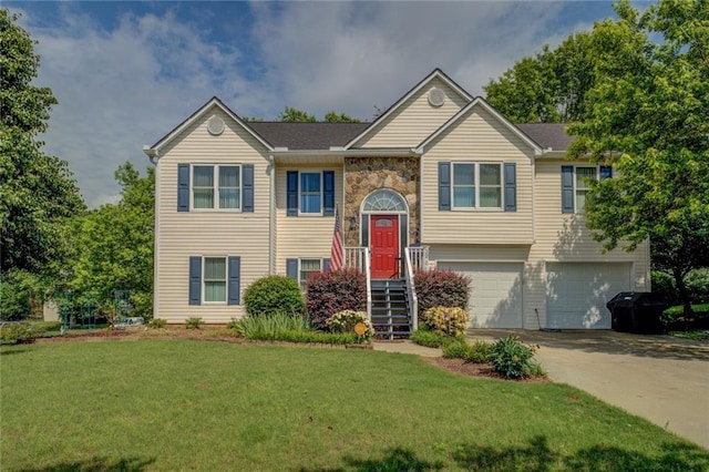 bi-level home with a garage, driveway, a front yard, and stone siding