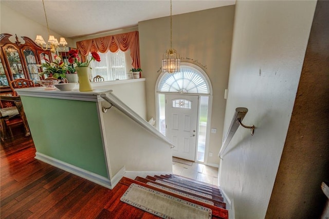 entryway with a chandelier, wood finished floors, and baseboards