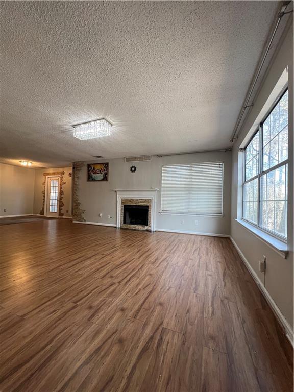 unfurnished living room with dark wood-type flooring and a textured ceiling