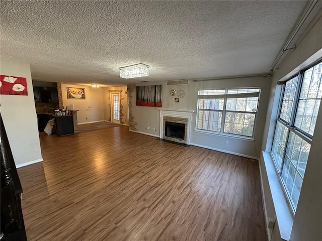 unfurnished living room with dark hardwood / wood-style floors and a textured ceiling