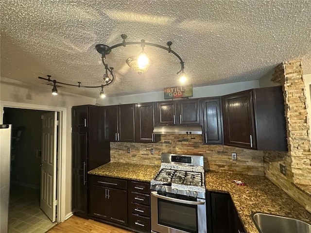 kitchen with rail lighting, tasteful backsplash, dark brown cabinetry, and appliances with stainless steel finishes