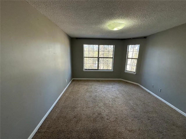 carpeted spare room with a textured ceiling