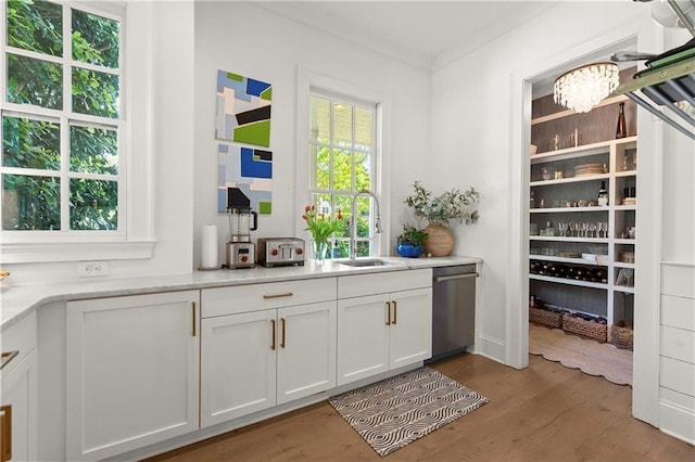 bar with dishwasher, a sink, wood finished floors, and a chandelier