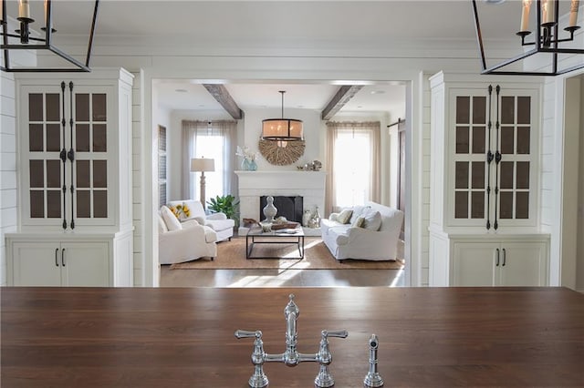 living room with plenty of natural light, french doors, a chandelier, and a brick fireplace