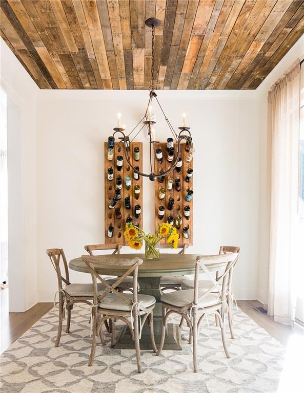 dining space featuring a chandelier, baseboards, wood ceiling, and light wood finished floors