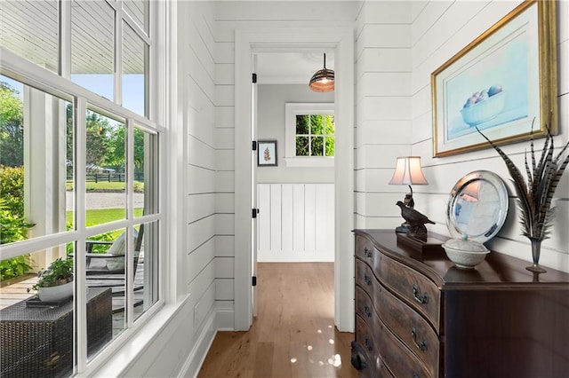 hallway with wood finished floors and a decorative wall