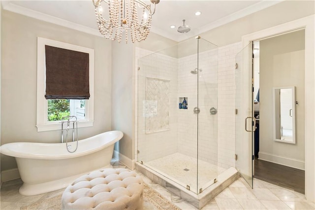 bathroom featuring baseboards, a stall shower, a freestanding tub, crown molding, and a chandelier