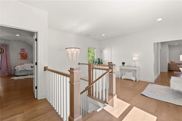 corridor with an upstairs landing, light wood-style flooring, a chandelier, recessed lighting, and baseboards