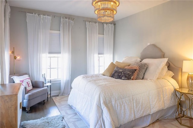 bedroom with a chandelier and baseboards