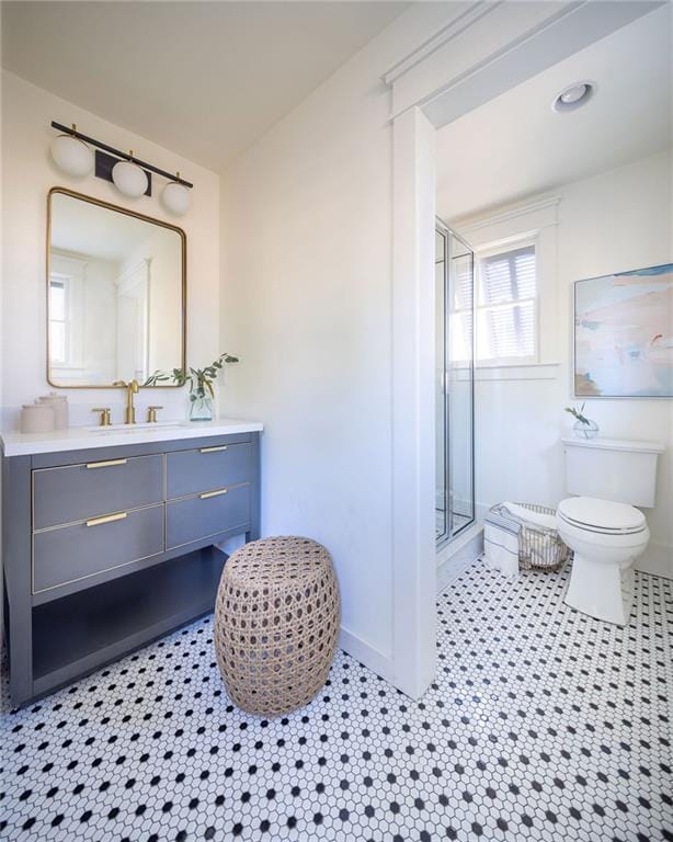 full bathroom featuring a shower stall, vanity, toilet, and tile patterned floors