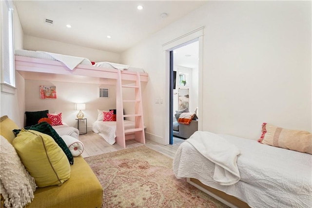 bedroom with wood finished floors and recessed lighting