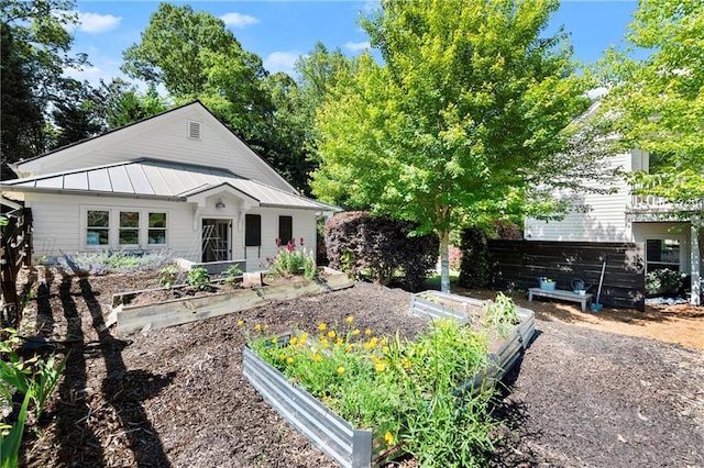 view of front of home with a garden, a standing seam roof, and metal roof
