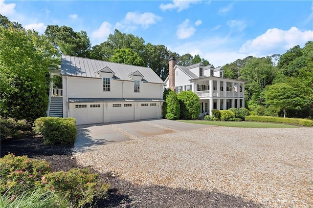 view of front of home with a standing seam roof, driveway, and metal roof