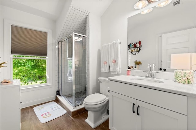 bathroom with a stall shower, wood finished floors, toilet, and vanity