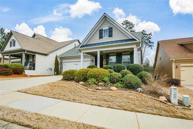 craftsman-style home featuring a garage, concrete driveway, and covered porch