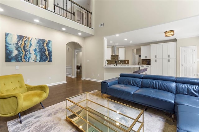 2055 Beacon Hill Way, Alpharetta, GA 30005 - living room featuring dark wood finished floors, arched walkways, a high ceiling, and recessed lighting