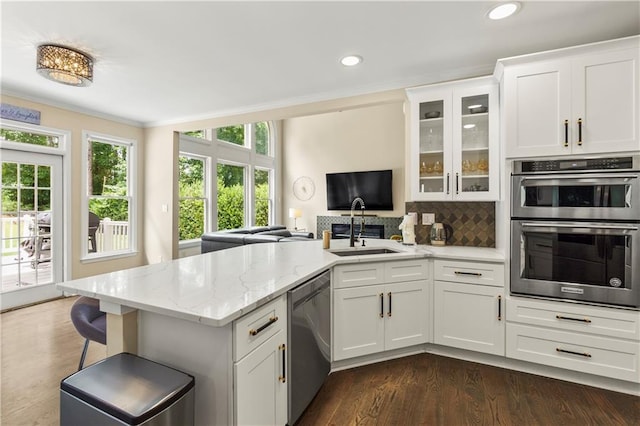 2055 Beacon Hill Way, Alpharetta, GA 30005 - kitchen with appliances with stainless steel finishes, a peninsula, white cabinets, dark wood-type flooring, and glass insert cabinets