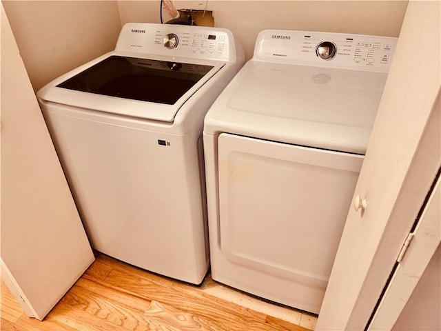 washroom featuring washing machine and dryer and light hardwood / wood-style floors