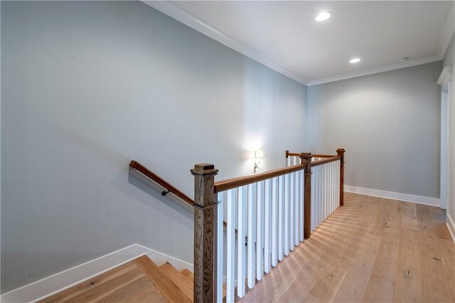 stairs featuring wood-type flooring and crown molding