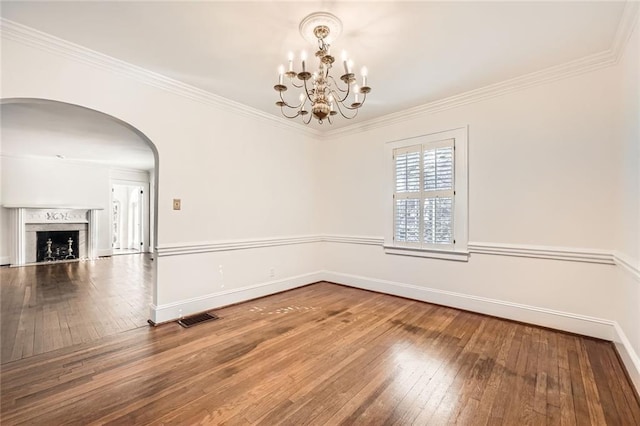 spare room with visible vents, ornamental molding, baseboards, and hardwood / wood-style flooring