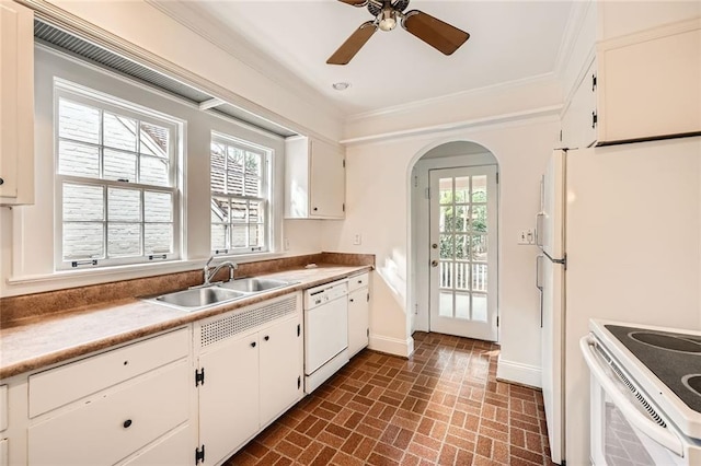 kitchen with arched walkways, ornamental molding, white appliances, and a sink