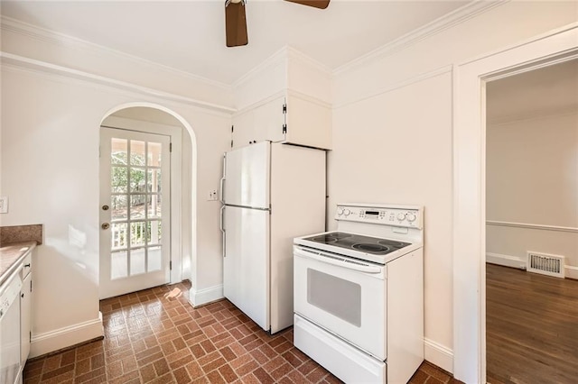 kitchen featuring visible vents, white appliances, baseboards, and crown molding