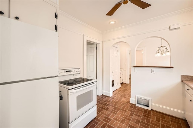 kitchen featuring white appliances, baseboards, visible vents, brick floor, and ornamental molding