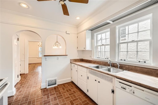 kitchen featuring white appliances, baseboards, visible vents, ornamental molding, and a sink