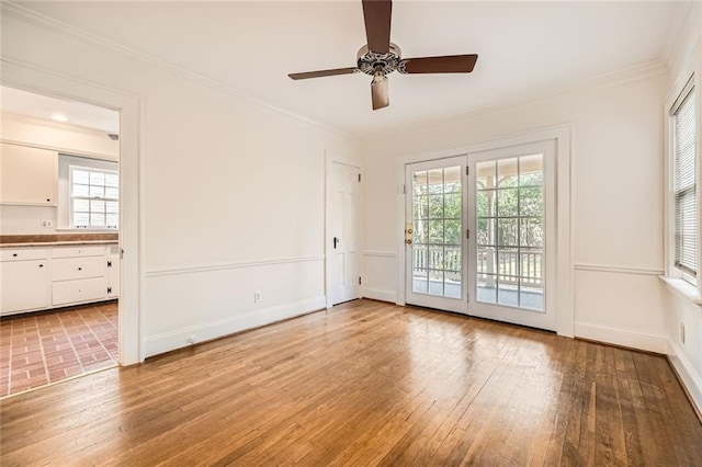 unfurnished room with crown molding, a ceiling fan, baseboards, and light wood finished floors