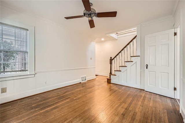 unfurnished room with visible vents, wood-type flooring, ornamental molding, and stairs