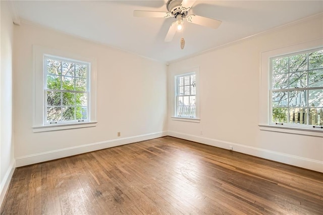 empty room featuring baseboards, wood-type flooring, and ornamental molding